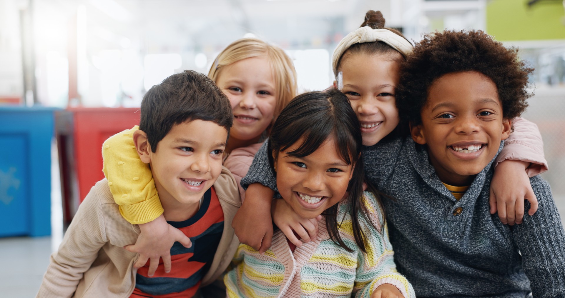 Portrait, groupe et enfants avec le sourire à l’école pour l’éducation, l’apprentissage et la connaissance avec câlin. Étudiant, enfants ou face au bonheur dans la salle de classe pour l’étude, la bourse ou le développement de l’enfance